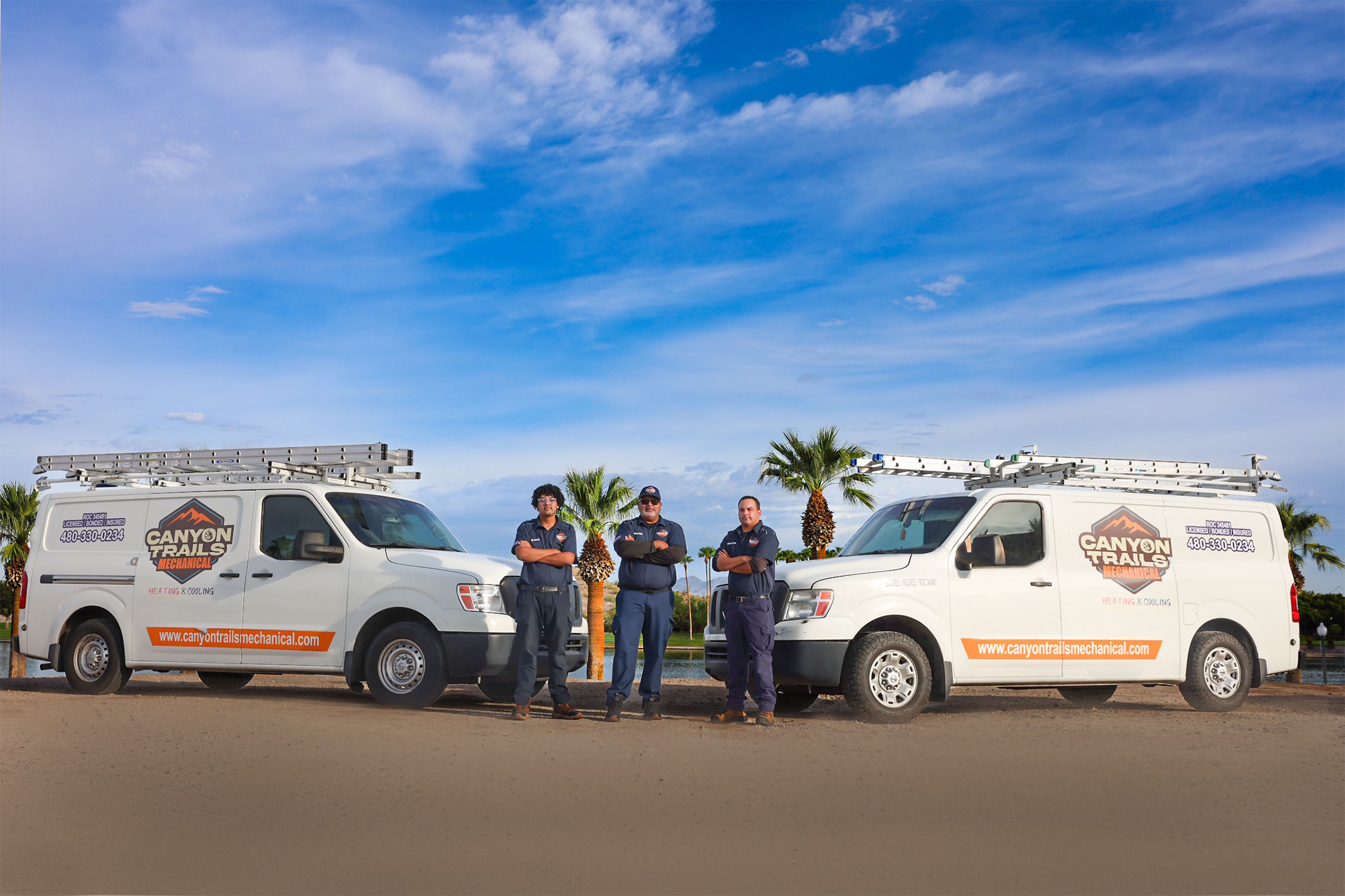 Canyon Trails Mechanical technicians standing between two service vans
