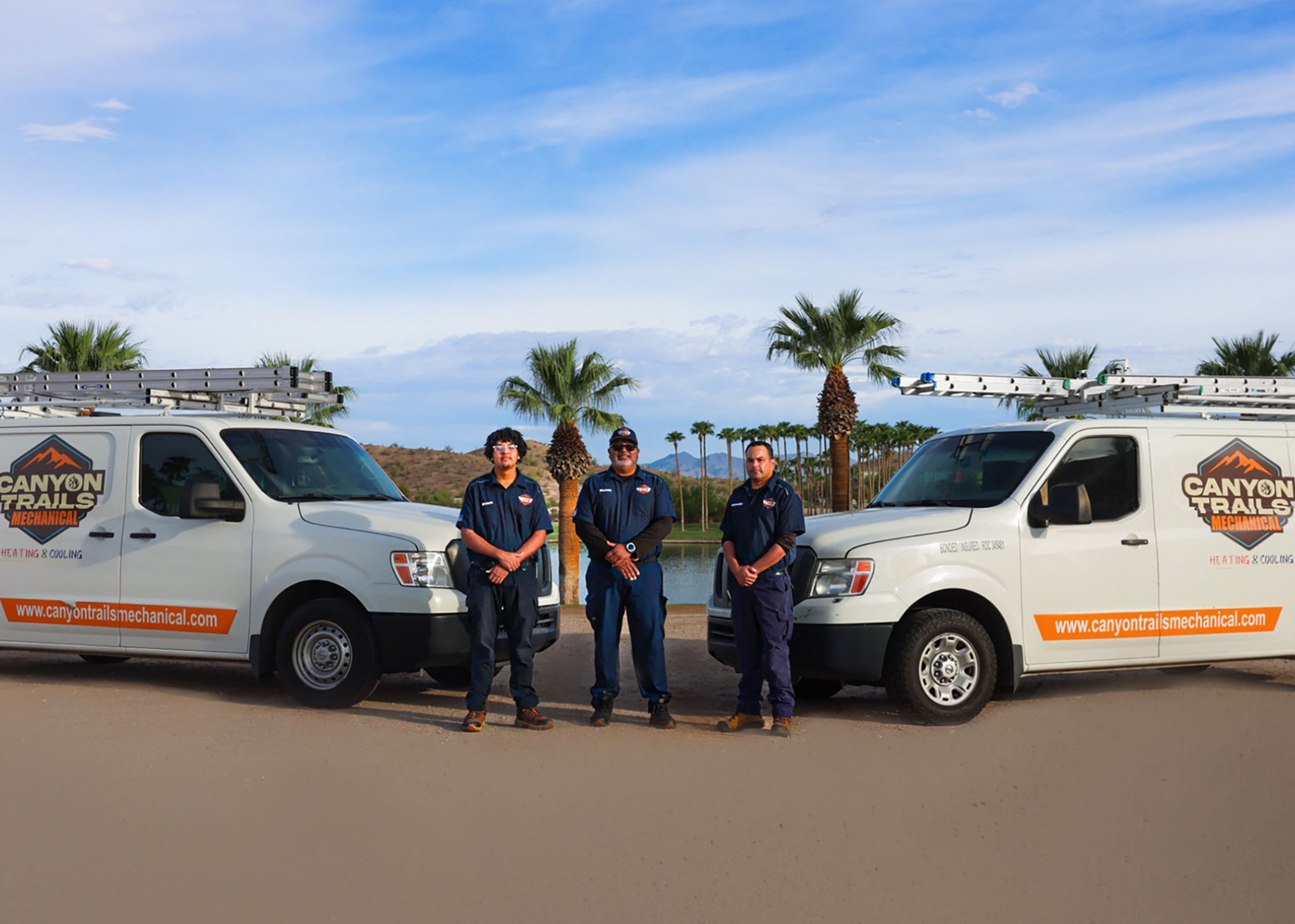 The Canyon Trails Mechanical team standing between two branded service vans