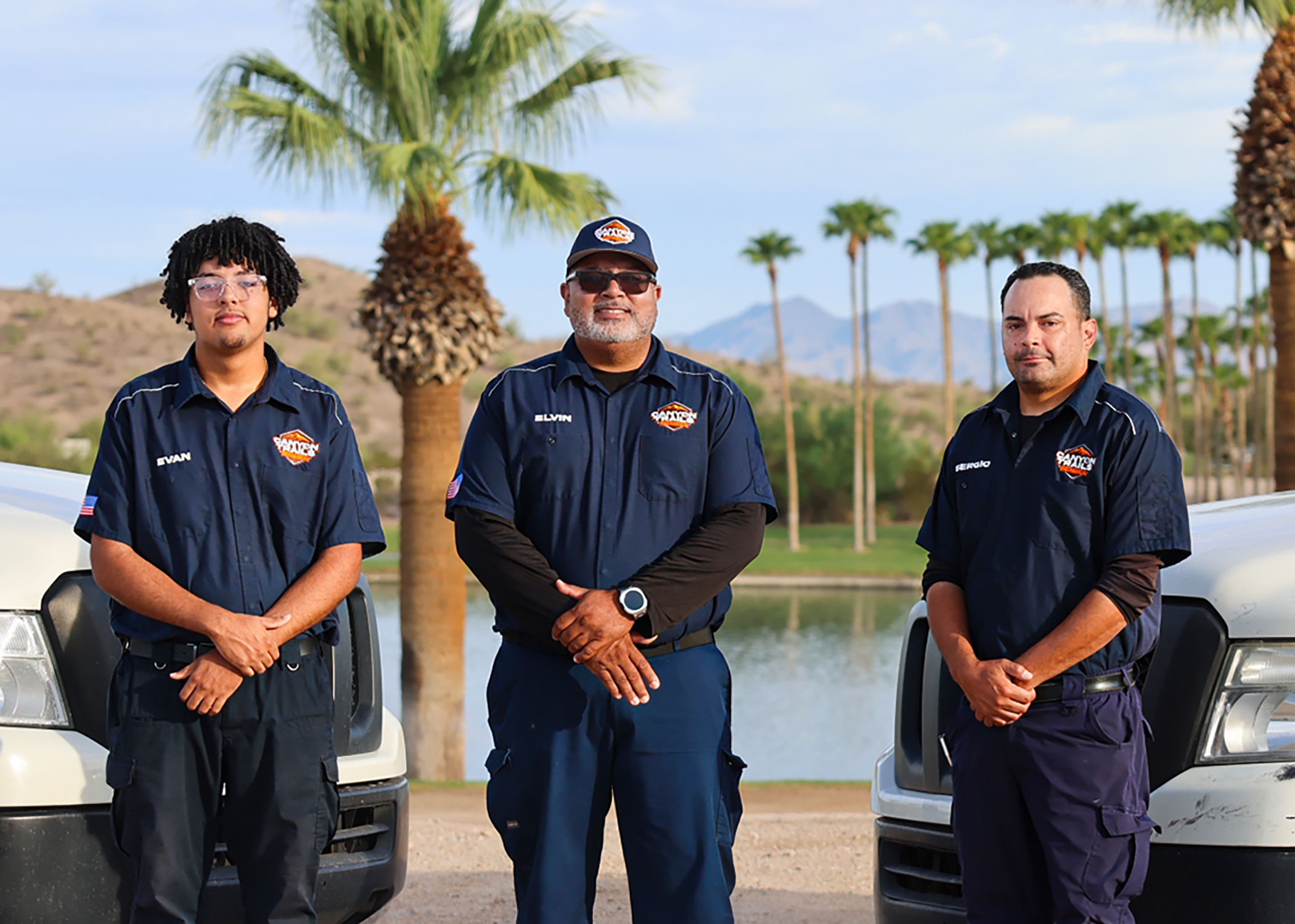 Evan, Elvin and Sergio of Canyon Trails Mechanical beside their service vans